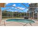 Enclosed screened pool featuring a custom safety rail and view of the backyard at 490 Knight Dr, Tarpon Springs, FL 34688