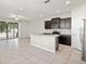 Open-concept kitchen features a large island, stainless steel appliances, and dark wood cabinetry at 5344 Sylvester Loop, Tampa, FL 33610