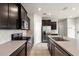 Modern kitchen featuring stainless steel appliances, dark cabinetry, and a center island at 5344 Sylvester Loop, Tampa, FL 33610