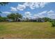 A sprawling backyard features lush green grass and mature trees, providing ample space for outdoor activities at 5507 Keeler Oak St, Lithia, FL 33547