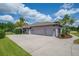 Spacious three-car garage featuring an extra-wide driveway and lush landscaping at 5507 Keeler Oak St, Lithia, FL 33547