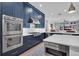 Modern kitchen featuring stainless steel appliances, custom blue cabinets, and a spacious island at 5507 Keeler Oak St, Lithia, FL 33547