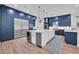 Modern kitchen with custom blue cabinetry, stainless steel appliances, and a large center island at 5507 Keeler Oak St, Lithia, FL 33547