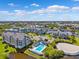 Community aerial view featuring a pool, waterfront homes, and well-maintained landscaping under a clear blue sky at 5712 Biscayne Ct # 103, New Port Richey, FL 34652