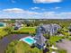 Aerial view of residential buildings by the water featuring a community pool, lush landscaping, and parking at 5712 Biscayne Ct # 103, New Port Richey, FL 34652