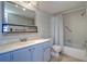 Bathroom featuring blue vanity, a large mirror, updated fixtures, and a shower-tub combo at 6020 Shore S Blvd # 503, Gulfport, FL 33707