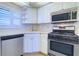 Kitchen featuring stainless steel appliances, white cabinets, and tile floors at 6020 Shore S Blvd # 503, Gulfport, FL 33707