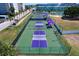Aerial view of community pickleball courts with green surface and purple accents near waterfront at 6020 Shore S Blvd # 503, Gulfport, FL 33707