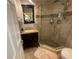 Well-lit bathroom with a glass enclosed shower, stone floors, and a wood vanity at 6073 115Th N Ave, Pinellas Park, FL 33782