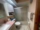 This bathroom has a shower-tub combination with sliding glass doors, vanity with pink marble, and a mirrored wall cabinet at 6073 115Th N Ave, Pinellas Park, FL 33782