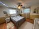 A well-lit bedroom with hardwood floors, decorative lamps, a ceiling fan, and a cozy bed with decorative pillows at 6073 115Th N Ave, Pinellas Park, FL 33782