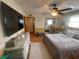 A bedroom boasting a large television, decorative furniture, hardwood floors, and a ceiling fan above the cozy bed at 6073 115Th N Ave, Pinellas Park, FL 33782