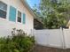 Exterior view of a white home with blue shutters, a screened lanai, and a white privacy fence at 6073 115Th N Ave, Pinellas Park, FL 33782