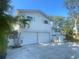 Charming two-story home featuring a two-car garage, white brick accents, and lush landscaping at 6073 115Th N Ave, Pinellas Park, FL 33782