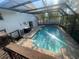 Sparkling in-ground pool surrounded by brick pavers and a screened enclosure at 6073 115Th N Ave, Pinellas Park, FL 33782