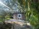Backyard storage shed in a wooded area with a stone paver pathway leading up to the structure at 6073 115Th N Ave, Pinellas Park, FL 33782