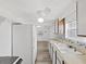 Kitchen features laminate flooring, white appliances, and tile backsplash at 6610 Myrna Dr, Tampa, FL 33619