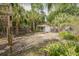 View of the backyard features tropical foliage, a detached gazebo, and a wood fence at 6904 S Fitzgerald St, Tampa, FL 33616