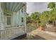 A cozy side-yard view from the porch features brick pavers, greenery and mature plantings at 6904 S Fitzgerald St, Tampa, FL 33616