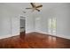 Light-filled bedroom features hardwood floors, an open doorway, and access to the balcony at 6904 S Fitzgerald St, Tampa, FL 33616