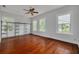 Bright bedroom features hardwood floors, modern windows, ceiling fan and a metal closet organizer at 6904 S Fitzgerald St, Tampa, FL 33616