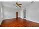 Bedroom with dark-stained hardwood floors, modern lighting, and an open doorway at 6904 S Fitzgerald St, Tampa, FL 33616