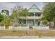 Charming two-story home with a wide porch, white picket fence, and lush green trees at 6904 S Fitzgerald St, Tampa, FL 33616