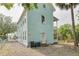 Charming light blue multi-story home featuring a side gravel area with a small door and a balcony at 6904 S Fitzgerald St, Tampa, FL 33616