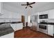 Traditional kitchen featuring white cabinets, stainless steel appliances, dark countertops, and hardwood floors at 6904 S Fitzgerald St, Tampa, FL 33616