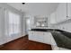 Charming kitchen with white cabinets, dark granite countertops, a stainless steel sink, and natural light from a window at 6904 S Fitzgerald St, Tampa, FL 33616