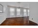 Light-filled room showcases hardwood floors, neutral walls, and multiple windows dressed with sheer curtains at 6904 S Fitzgerald St, Tampa, FL 33616