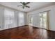 Bright living room features dark wood floors, neutral walls, multiple windows, and glass doors leading to the deck at 6904 S Fitzgerald St, Tampa, FL 33616