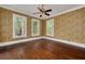 Bright living room featuring hardwood floors, floral wallpaper and natural light from several windows at 6904 S Fitzgerald St, Tampa, FL 33616