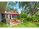 Inviting backyard with a patio dining set under an umbrella, screened in porch, and lush landscaping at 7208 Pointe West Blvd, Bradenton, FL 34209