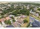 An aerial view of a pond-front community showcasing various homes surrounded by mature trees at 7606 Nottinghill Sky Dr, Apollo Beach, FL 33572