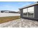Home exterior featuring backyard with paver patio and view of screened pool at 7606 Nottinghill Sky Dr, Apollo Beach, FL 33572