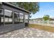 View of fenced backyard and lanai with grey brick pavers at 7606 Nottinghill Sky Dr, Apollo Beach, FL 33572