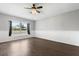 Bedroom featuring wood floors, window with views, and neutral paint at 7606 Nottinghill Sky Dr, Apollo Beach, FL 33572