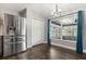 Dining area boasts large window, stainless steel refrigerator, and modern lighting fixture at 7606 Nottinghill Sky Dr, Apollo Beach, FL 33572