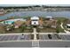 An aerial view of community center with pool, playground, parking, and lake views at 8214 Wheat Stone Dr, Zephyrhills, FL 33540