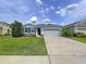 Charming single-story home with a well-maintained lawn, driveway, and manicured landscaping at 8214 Wheat Stone Dr, Zephyrhills, FL 33540