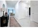 Bright hallway with neutral paint, tile floors, and doors leading to various rooms at 8214 Wheat Stone Dr, Zephyrhills, FL 33540