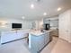 Open living area featuring a kitchen island, modern gray cabinetry, and a spacious seating area with a TV at 8214 Wheat Stone Dr, Zephyrhills, FL 33540