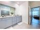 Stylish bathroom featuring dual vanities, granite countertops, and a separate door to the toilet and shower at 8214 Wheat Stone Dr, Zephyrhills, FL 33540