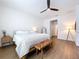 Bright main bedroom featuring a ceiling fan, hardwood floors, and a cozy seating area with a bench at 8214 Wheat Stone Dr, Zephyrhills, FL 33540