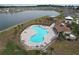 Aerial view of a community pool and recreation area by a lake at 8214 Wheat Stone Dr, Zephyrhills, FL 33540