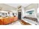 Stylish bathroom with a soaking tub, walk-in shower, and wood cabinets at 9535 Norchester Cir, Tampa, FL 33647