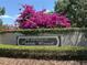 The Estates of Pebble Creek community sign with vibrant bougainvillea and lush greenery at 9535 Norchester Cir, Tampa, FL 33647