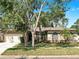 Charming single-story home with a well-manicured lawn, beautiful landscaping, and an attached two-car garage at 9535 Norchester Cir, Tampa, FL 33647