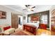 Comfortable main bedroom with wood floors, a large bed, and sliding barn door to the bathroom at 9535 Norchester Cir, Tampa, FL 33647